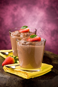 茶匙树叶一杯美味的巧克力慕斯加草莓和黄餐巾纸图片