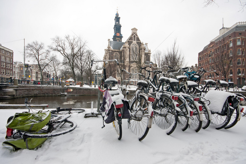 自行车传统的荷兰冬季与Westerkerk人一起在荷兰的Snowy阿姆斯特丹水图片