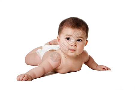 快乐的哈基又有趣可爱的白人西班牙裔婴儿躺在肚子上穿着尿布与世隔绝背景图片