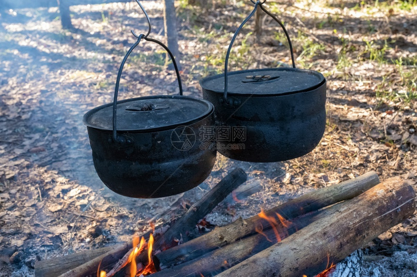 热的超过两个黑烟熏锅悬在燃烧的营火上俄罗斯图片