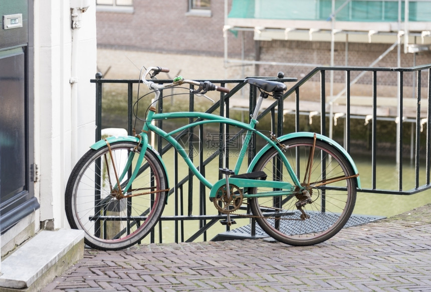 街道车轮在Holland街上骑着绿色自行车的住宅和运河屋图片