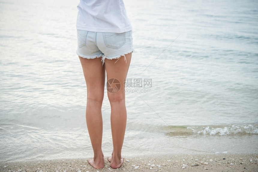 人们年轻的女士赤脚站在海滩上女图片