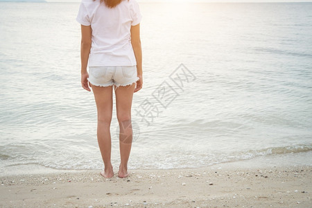 夏天水松弛年轻女士赤脚站在海滩上图片