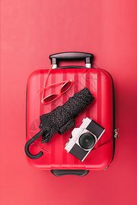 红色的旅行手提箱红色墨镜旧照相机红背景黑色雨伞和红墨镜离开老的图片