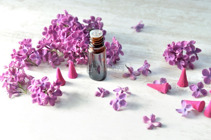 花底紫色薄膜的香和基本油瓶水治疗花瓣图片