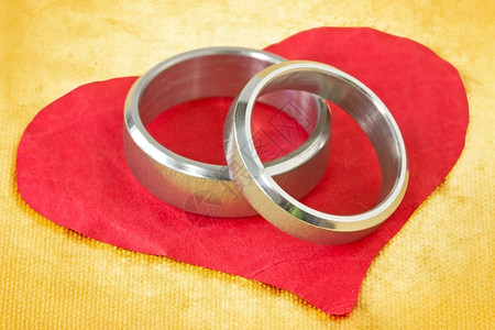 婚礼皱巴的浪漫红圆纸心上的婚戒指图片