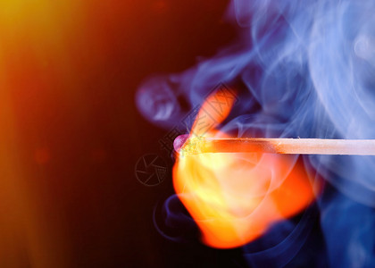 火焰色的素材黑暗的色火柴棍与背景的蓝烟雾相匹配设计图片