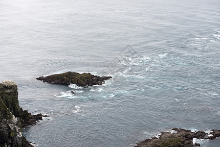 强大的洋流和靠近法罗群岛密基内斯的海流和礁石英法罗群岛大西洋危险岩石背景图片