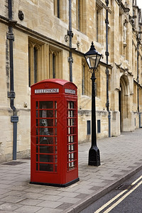 在英国牛津Magdalen学院外的一条街上英式电话箱外部红色的一种图片