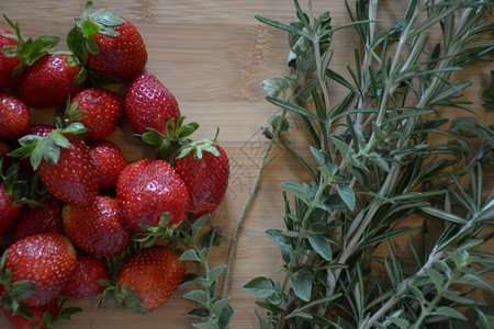 水果伐木板上的草莓和及药红色的食用图片