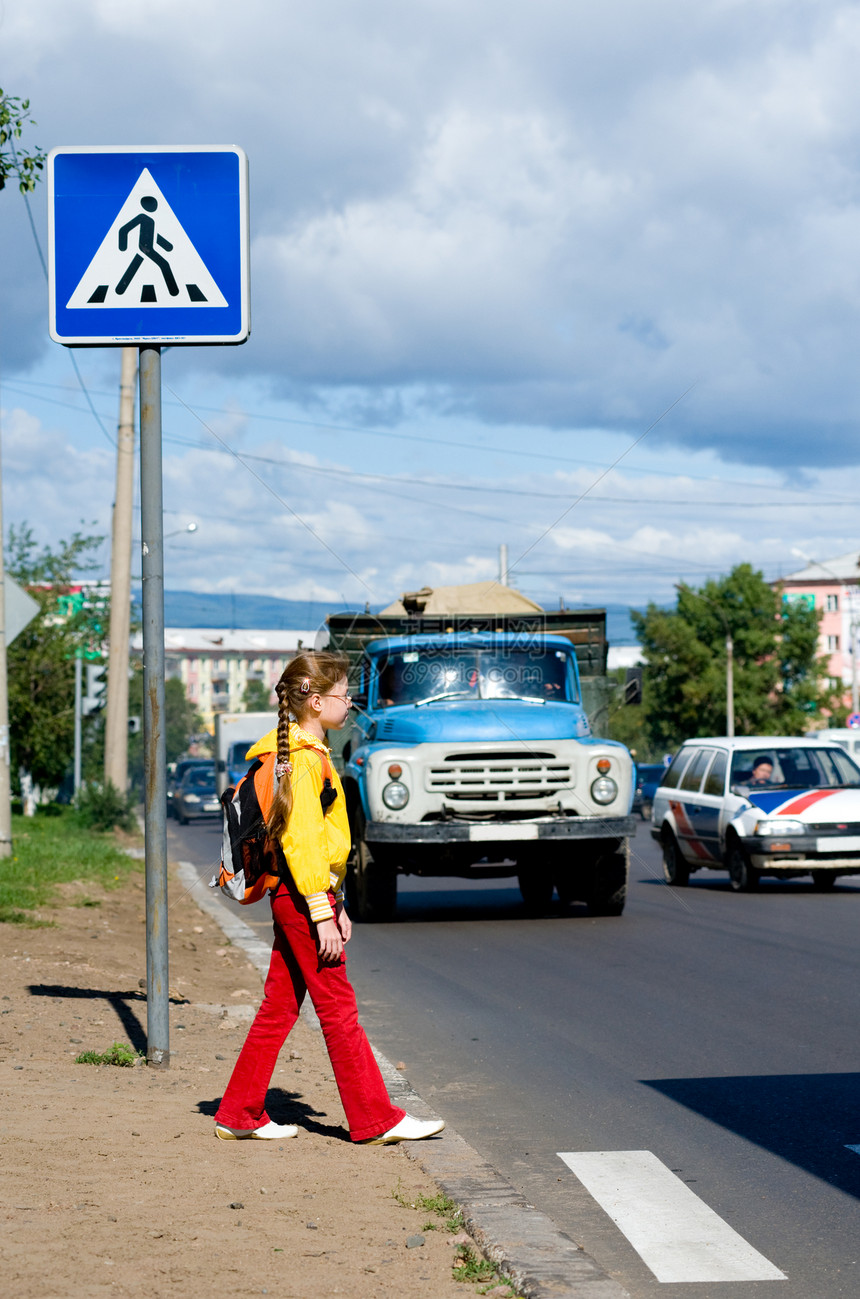 叉交通行人9岁女孩背着破烂车走过路面图片