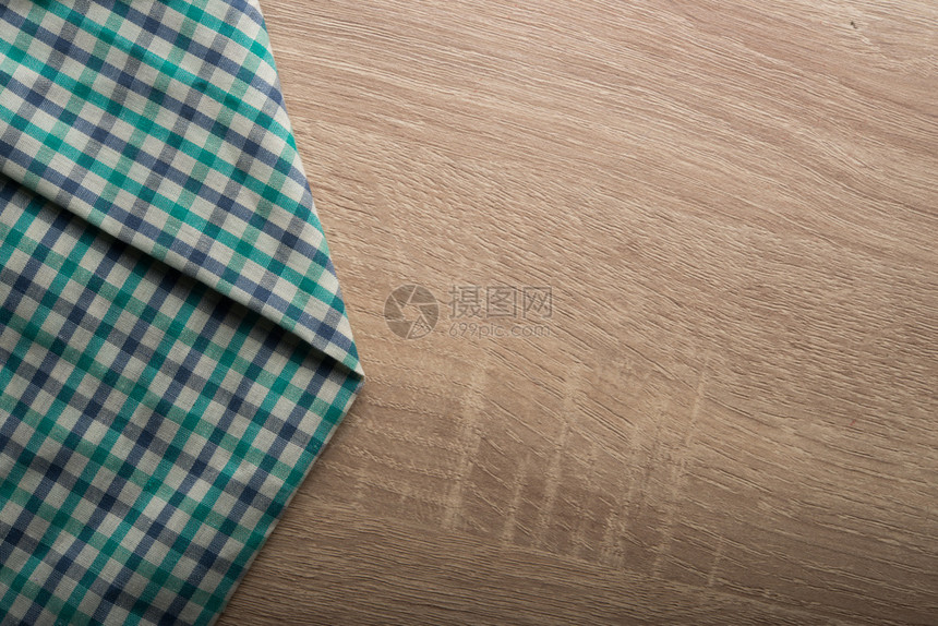 木制背景上的格子绿色餐巾纸木制背景上的格子绿色餐巾纸桌布质地空的图片