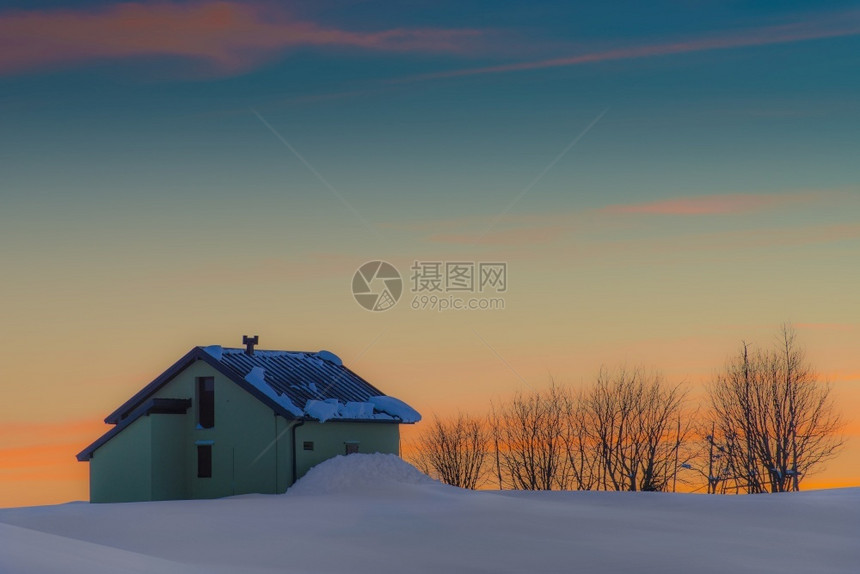 夕阳下的雪中小屋图片