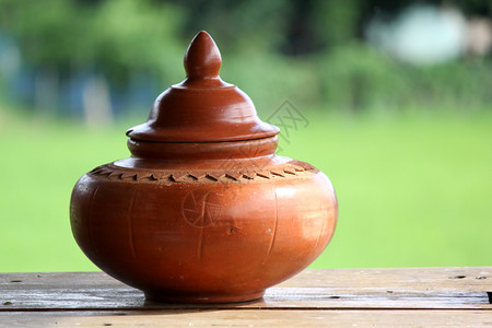 土壤木板上盖有子的手工制作粘土锅传统棕色背景图片