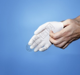 卫生白色的一名医穿戴或摘除白色乳胶橡保护手套推杆图片
