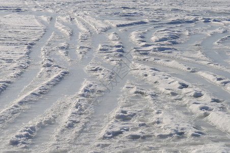 晴天带轮胎足迹和脚印的冰冻面背景阳光冬日追踪痕迹图片