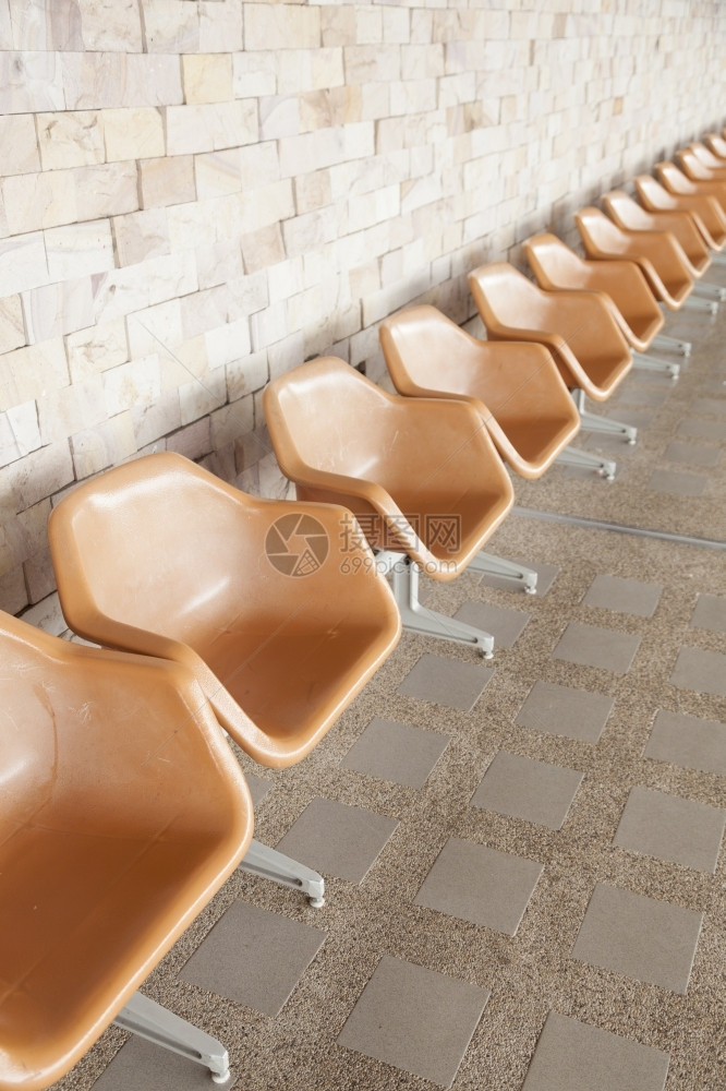 橙子色塑料椅沿走廊排成一椅子座位图片