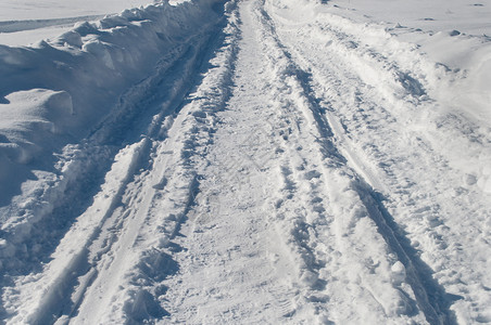 追踪小路雪堆阳光明日覆盖的乡村道路背景图片