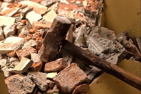 木制的材料拆除碎砖墙上的旧木锤图片