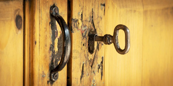 安全旧钥匙锁在破的木制门锁上的优质图片
