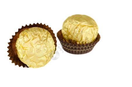 单身的金子巧克力包裹着金色的巧克力在白色上被隔绝甜点图片