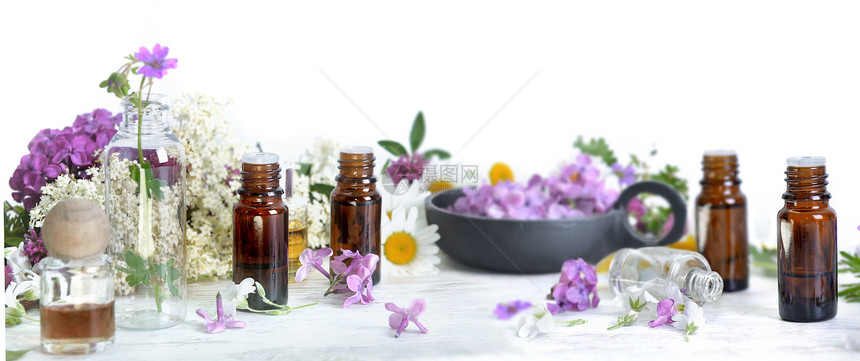 很少瓶子几精油在白色背景的桌子上花瓣间几瓶精油在白色背景的桌子上花瓣间朵图片