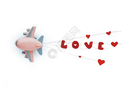 粉色小飞机粉色的塑像单词玩具飞机和明亮的红色字眼在白背景后的绳索上爱背景