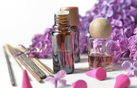 芳香疗法治花底紫色薄膜的香和基本油瓶紫色的背景图片