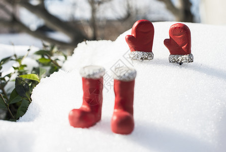 寒冷的圣诞靴子雪上戴手套的圣诞靴子和手套木制的树图片