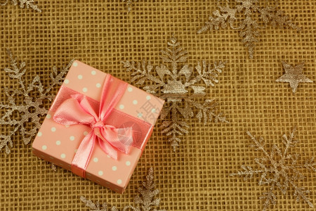 顶部免费平坦的粉红盒绑在圣诞节背景的粉红色丝带上礼物有趣的装饰品平板从右侧自由顶端复制空间的横向视图假日背景图片