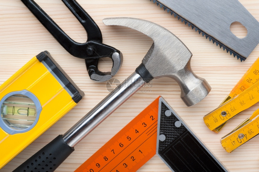 建造锤子安排好的以木制表面为建筑修理或房屋改良背景安排的各类建筑和测量工具建筑修理或住房改造背景图片