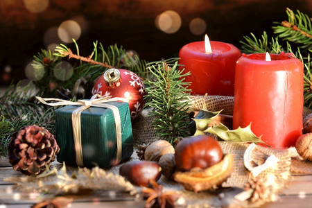 庆典木制背景上的传统圣诞节装饰蜡烛和鲜光明灯的礼物冷杉木板图片