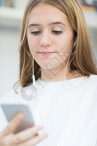 青春期耳机来自移动电话的青少年女孩流动音乐Name在室内图片
