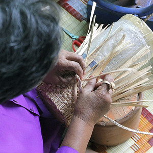 村民拿竹篾编织篮子柳条手工制作的业背景图片