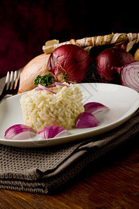 白饭素食主义者木制桌上有红洋葱的美味炖饭照片图片