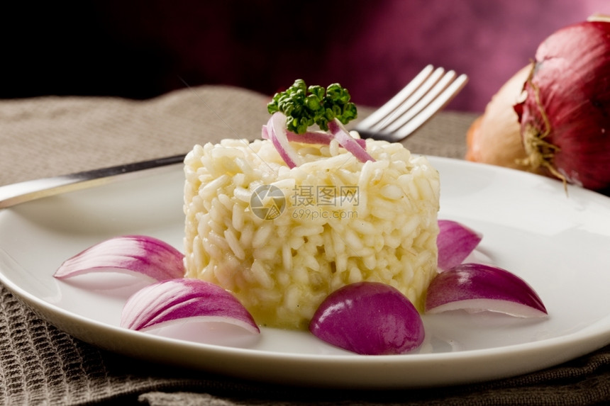 美味的木制桌上有红洋葱的美味炖饭照片意大利语美食图片