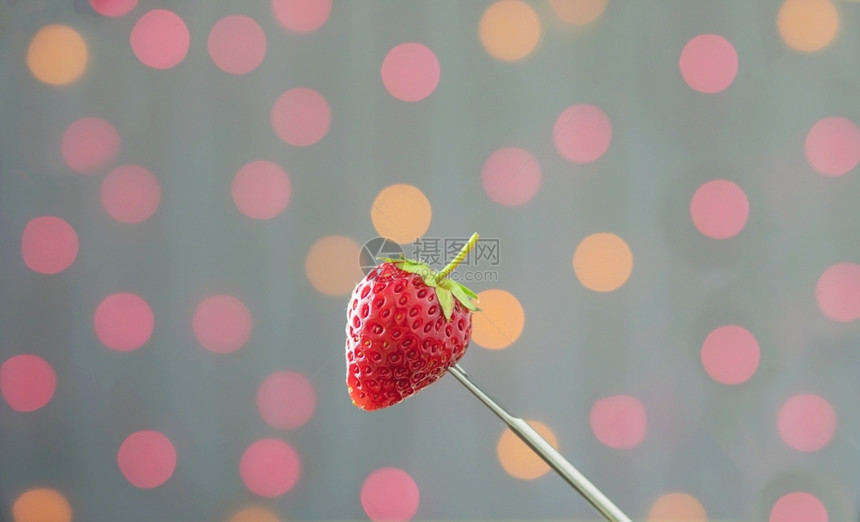 超过所有的丰富多彩色光线bokeh背景上的新鲜草莓图片
