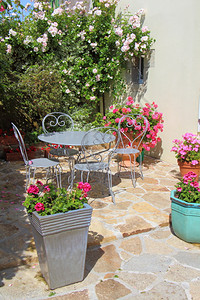 开花的椅子朵露台有灰色花园家具和春天一些带环的花盆锅背景图片