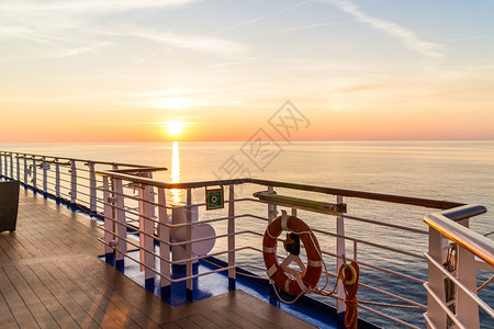 船栏杆太阳水救生带法国海岸外地中的一艘游船日落时升起背景