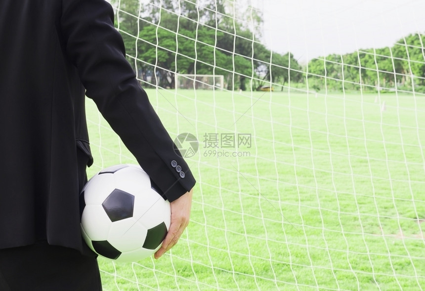团队抽象的教练足球队长正拿着目标网和绿草地背景的球图片