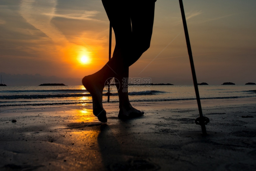 一名女子在日出时海滩散步练习卫军时腿部的详情细节身体步行图片