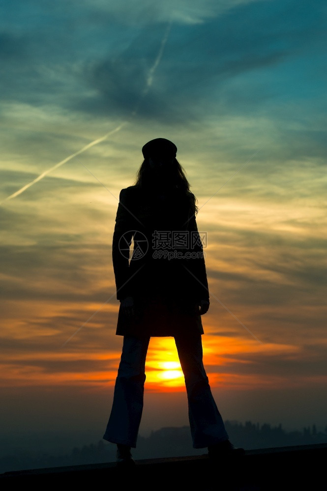女孩与太阳站在双腿之间周光中黎明城市日落图片