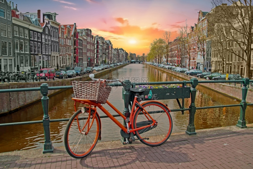 传统的运河荷兰阿姆斯特丹市中心的橙色自行车日落时分荷兰阿姆斯特丹市中心的橙色自行车日落时分首都图片