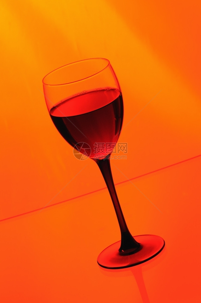浇注喷射橙色背景的红酒葡萄精图片
