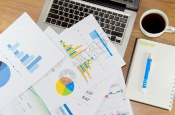 市场数据桌上有手提笔书本咖啡和笔的财务图表研究图片