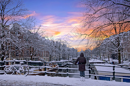 屋荷兰的阿姆斯特丹冬季日落时雪积覆盖荷兰阿姆斯特丹黄昏建筑的图片