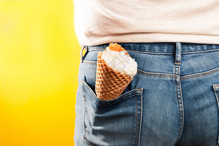 颜色门户14背部黄色景的牛仔裤口袋中冰淇淋甜筒图片