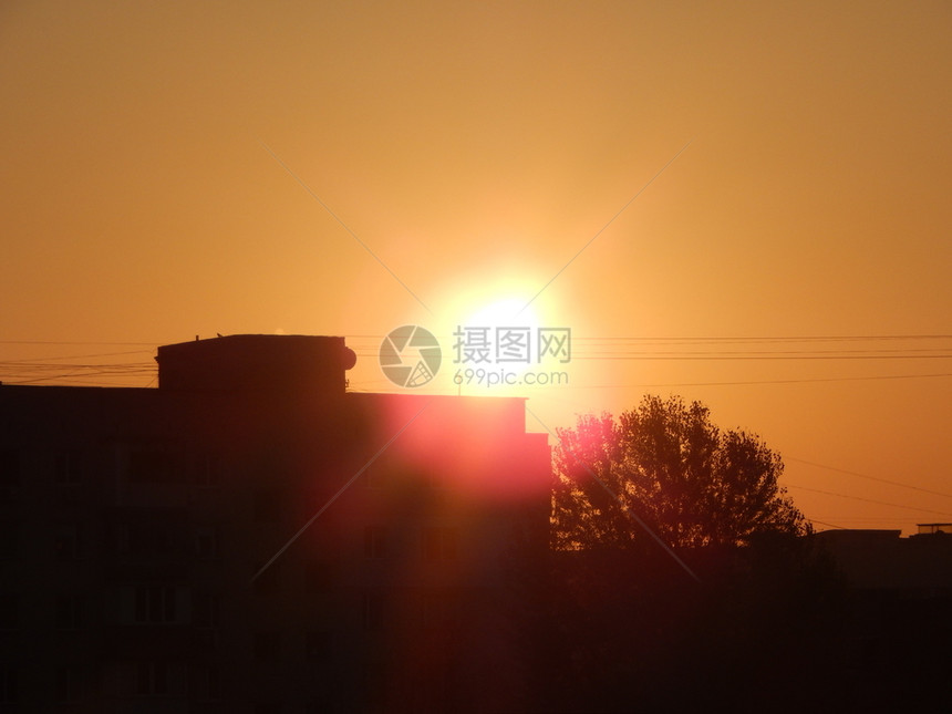 旅行日落黄色的城市中太阳黎明和房屋建筑结构的反射在城市中图片