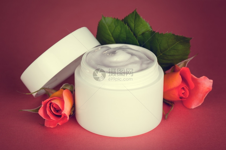 化妆品白色的温泉粉红背景面霜上有粉红色底的玫瑰花图片
