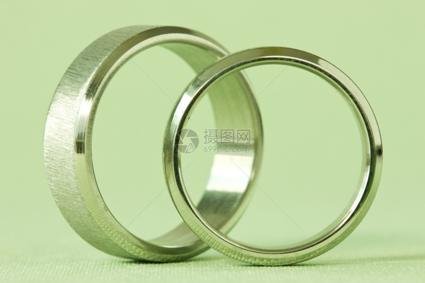 绿色背景的两枚结婚戒指姻奢华圆形的图片